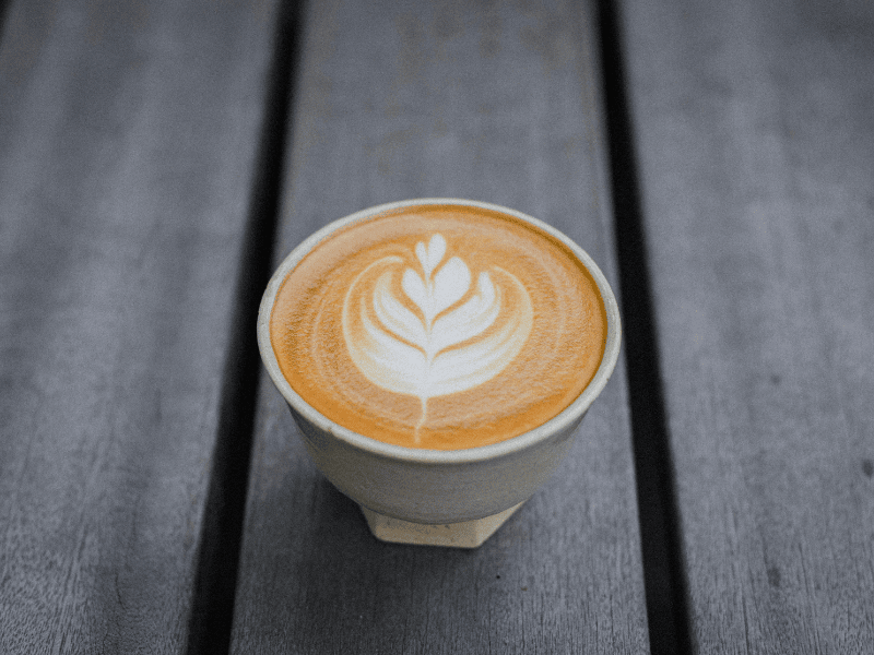 Cup of coffee with latte art on a wooden surface