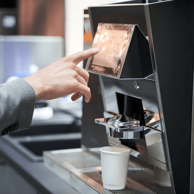 Customer selecting a drink on an instant coffee machine
